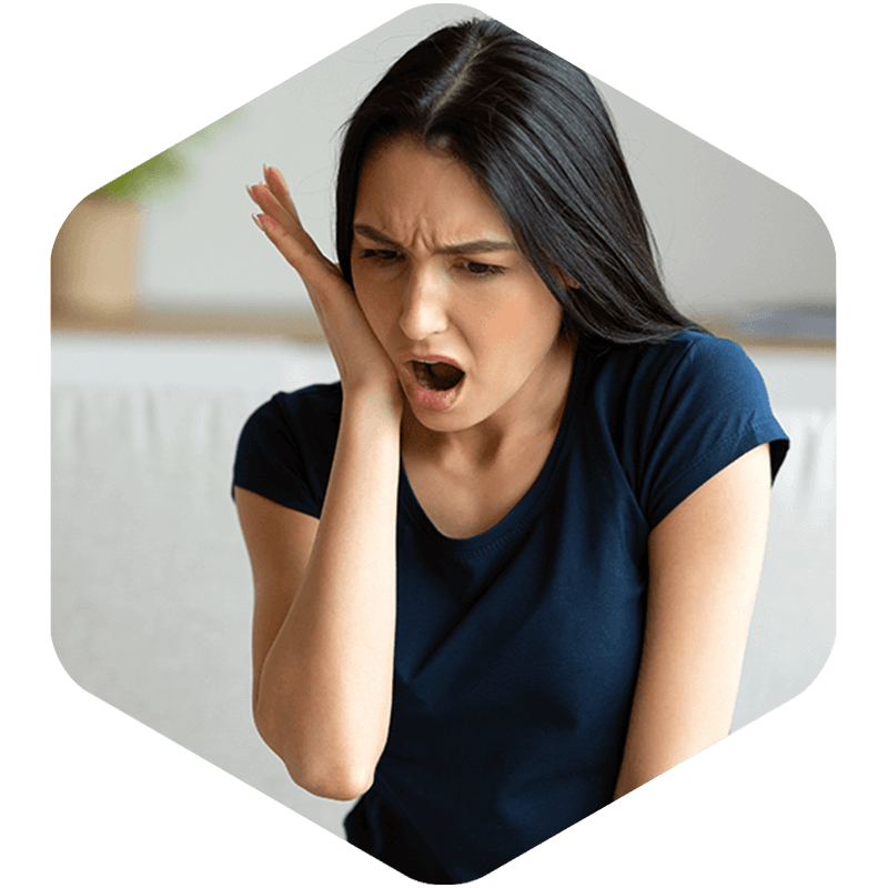 A woman touching her cheek in pain.